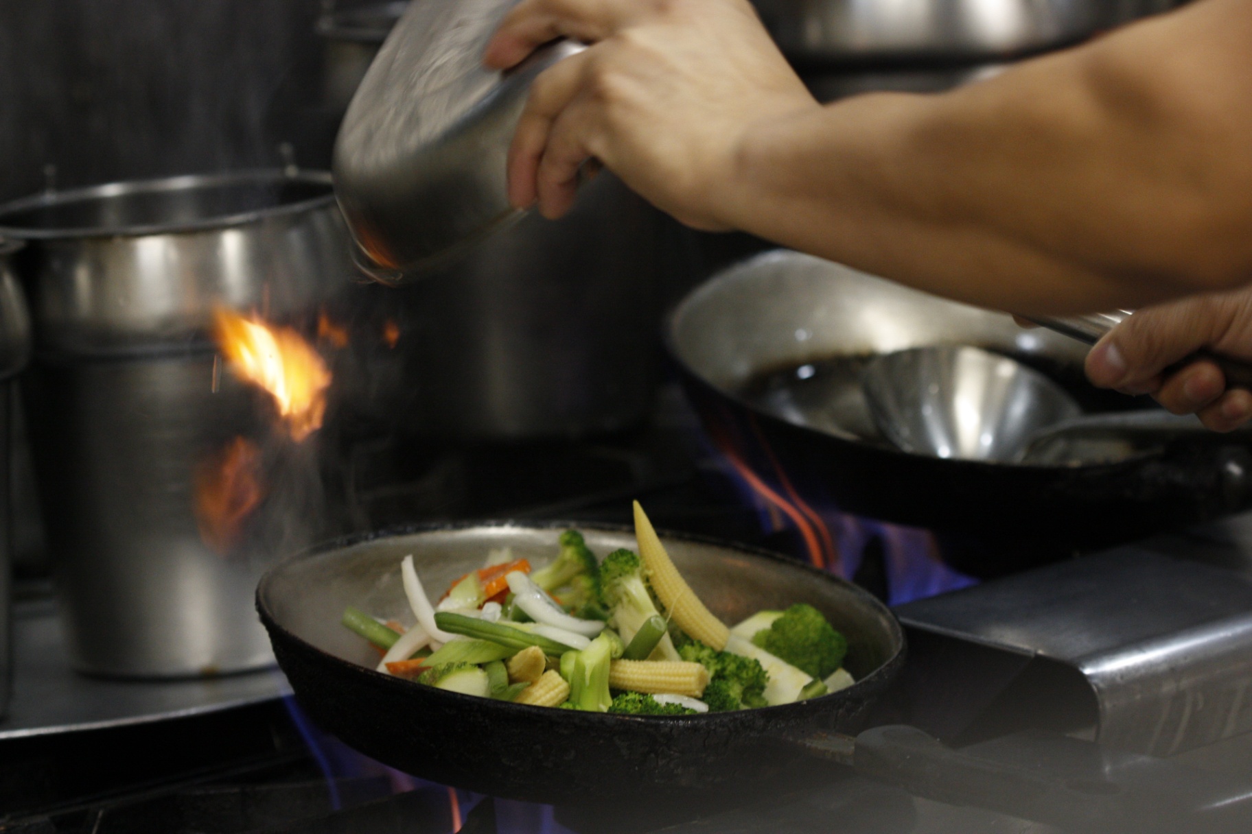 Fresh vegetables in a wok over open flame